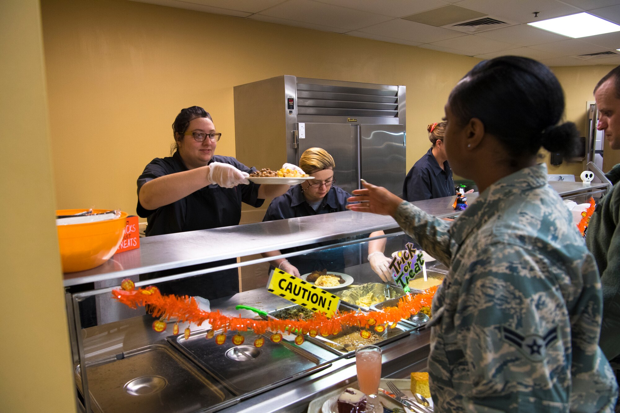 Josey Withrow, food services worker, serves food to Airmen during Soul Food Sunday at Grissom Air Reserve Base, Ind., Oct. 14, 2018. During Soul Food Sunday, the 434th Force Support Squadron prepared a menu including fried chicken, collard greens, barbecue ribs and macaroni and cheese. (U.S. Air Force photo / Senior Airman Harrison Withrow)