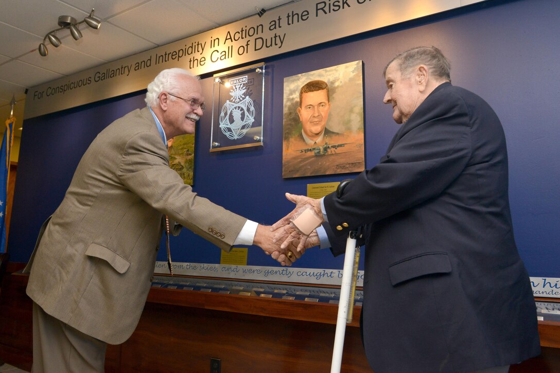 Two Medal of Honor recipients shake hands.