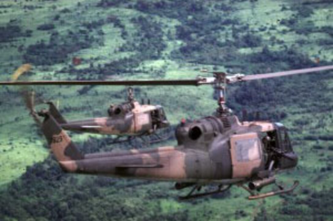 Helicopters fly over a jungle.