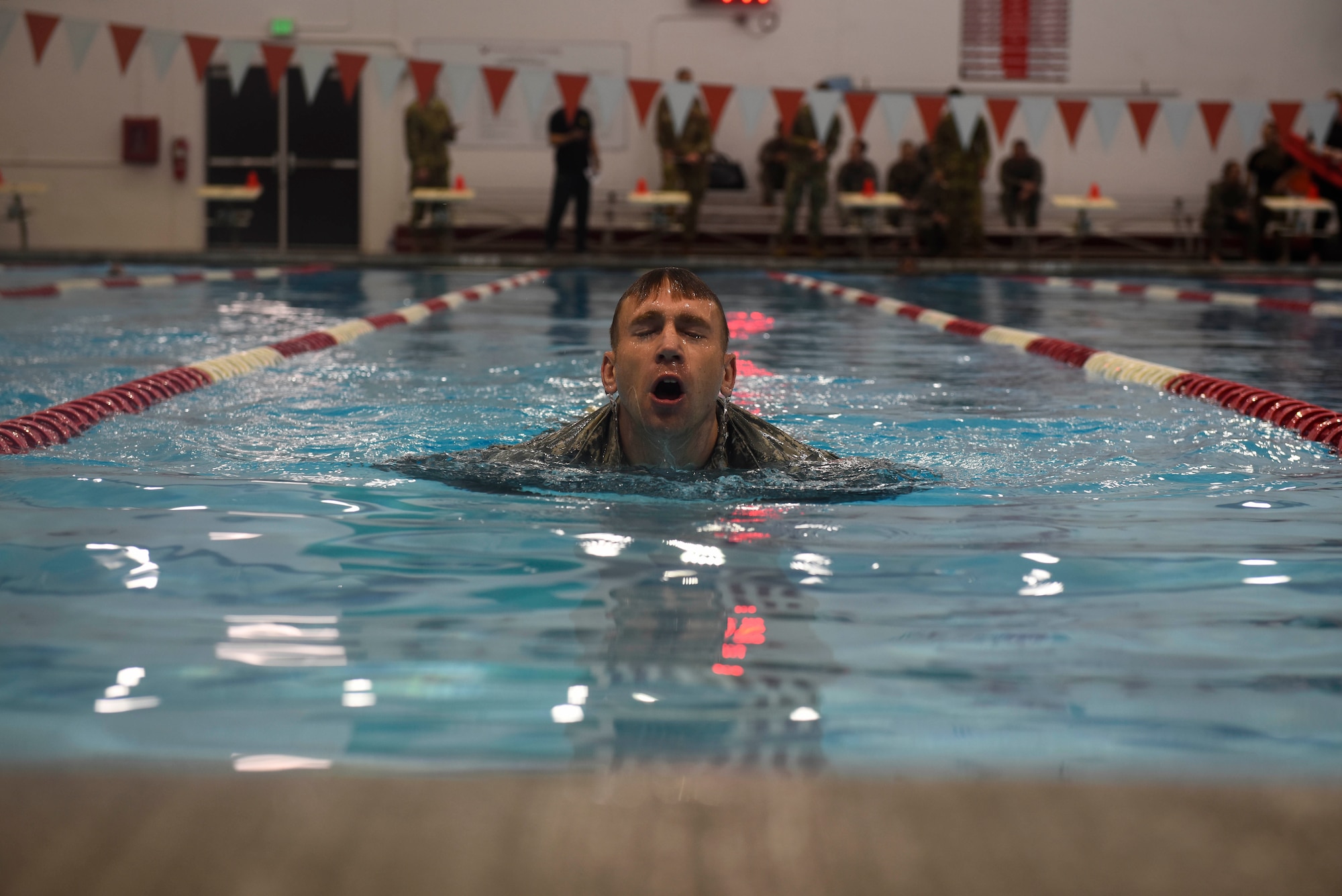 U.S. Air Force Staff Sgt. Christopher Munro, 92nd Maintenance Squadron Aerospace Ground Equipment craftsman, performs in the uniformed swim event during the German Armed Forces Proficiency Badge competition Nov. 17, 2018, at Eastern Washington University in Cheney, Washington. The GAFPB originates from the Bundeswehr, the unified armed forces of the Federal Republic of Germany, and can be awarded to any German or allied soldier. (U.S. Air Force photo/Airman 1st Class Lawrence Sena)