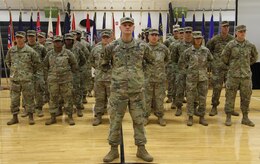 FORT KNOX, Ky. - Capt. Petro Mycio, officer in charge for the Alpha Company of 1st Theater Sustainment Command stands at parade rest in front of his unit during the deployment ceremony at the Sadowski Center, Nov 19. The team, comprised of Soldiers and Department of the Army Civilians, deploying to Kuwait where they will assume the Strategic Operations and Plans (SOaP) mission. (U.S. Army photo by Spc. Zoran Raduka)