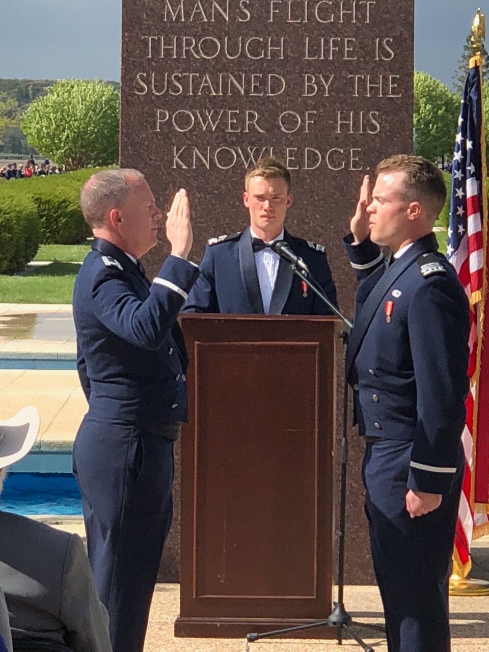 Two men raise hands in an Air Force commissioning ceremony