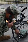 Navy Petty Officer 1st Class Albert A. Givens demonstrates how to set up a Mobile User Objective Service (MUOS), SATCOM system at Joint Task Force Civil Support (JTF-CS) on Nov. 19, 2018. The mobilization of the MUOS system enables communications for field and transit operations in a crisis response. When directed, JTF-CS is ready to respond in 24 hours to provide command and control of 5,200 federal military forces located at more than 36 locations throughout the nation in support of civil authority response operations to save lives, prevent further injury and provide critical support to enable community recovery. (Official DoD photo by U.S Air Force Tech. Sgt. Michael Campbell/ Released)