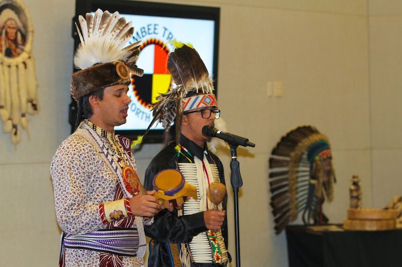 Kaya Littleturtle (left), the cultural enrichment coordinator for the Lumbee Tribe of North Carolina, and Ja’cobi Revels (right), a tribe member, sing traditional songs at U.S. Army Central’s National American Indian Heritage Month observance Nov. 15, 2018, at Patton Hall on Shaw Air Force Base, S.C. Littleturtle is the lead singer the Native American drum group “WarPaint”, which traveled all over the country and Canada winning many singing contests.