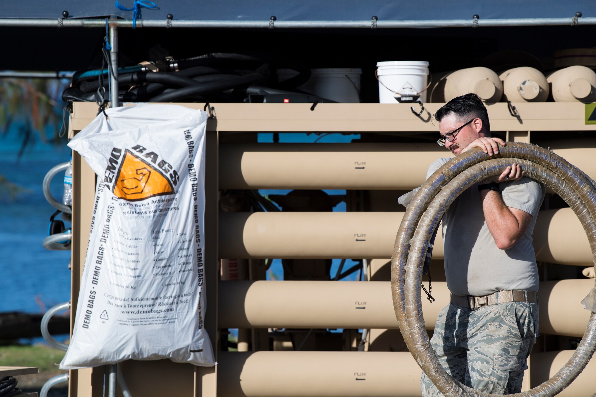 Senior Airman John McGovney, 36th Civil Engineer Squadron water and fuel systems maintainer assigned to Andersen Air Base, Guam, carries a hose during reverse osmosis water purification unit tear down on Saipan, Commonwealth of the Northern Mariana Islands, Nov. 21, 2018, as part of the Super Typhoon Yutu relief effort.