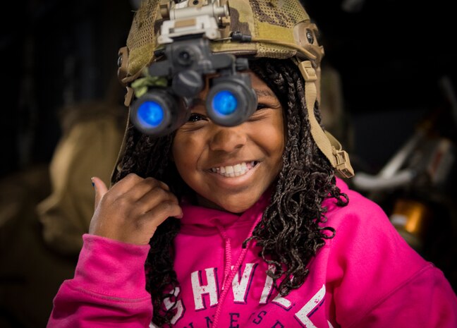Ruth Cottam tries on a helmet from the 66th Rescue Squadron at Nellis Air Force Base, Nevada, Nov. 16, 2018. Ruth’s dad, Dr. Daniel Cottam, was rescued by the 66th RQS when he suffered multiple broken bones from a hiking accident near Zion Canyon, Utah. (U.S. Air Force photo by Airman 1st Class Andrew D. Sarver)