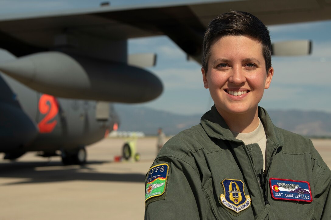 C-130J loadmaster, displays her unit patch in front of her aircraft