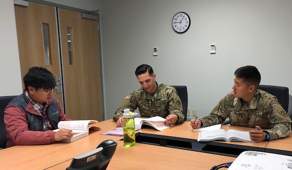 (Left to right) Myles Emsele, 1LT Zachary Hawkins, and 1LT Joshua Jang discuss Project Integration Management tools and techniques at the PMP study group on Nov. 20, 2018 to prepare for the PMP exam.