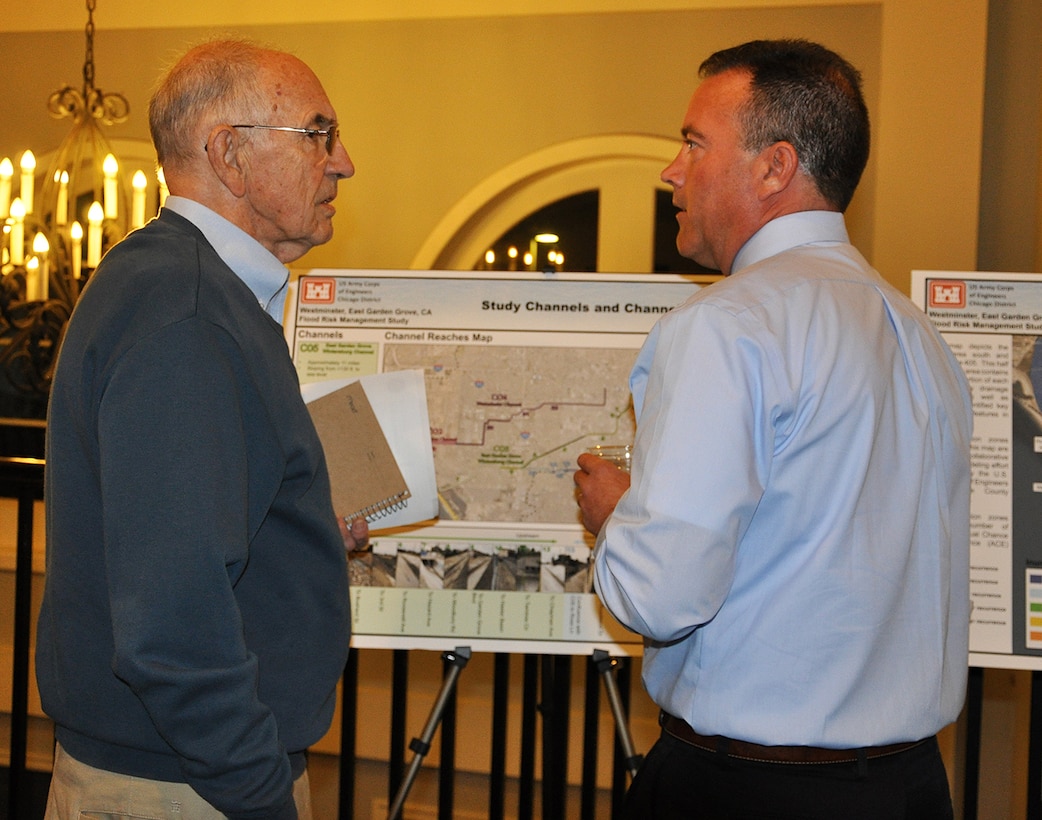 Joel Schmidt, hydraulic engineer with the U.S. Army Corps of Engineers Chicago District, right, speaks to a community member during a Nov. 8 public meeting about the Westminster/East Garden Grove Flood Risk Management Study in Huntington Beach, California.