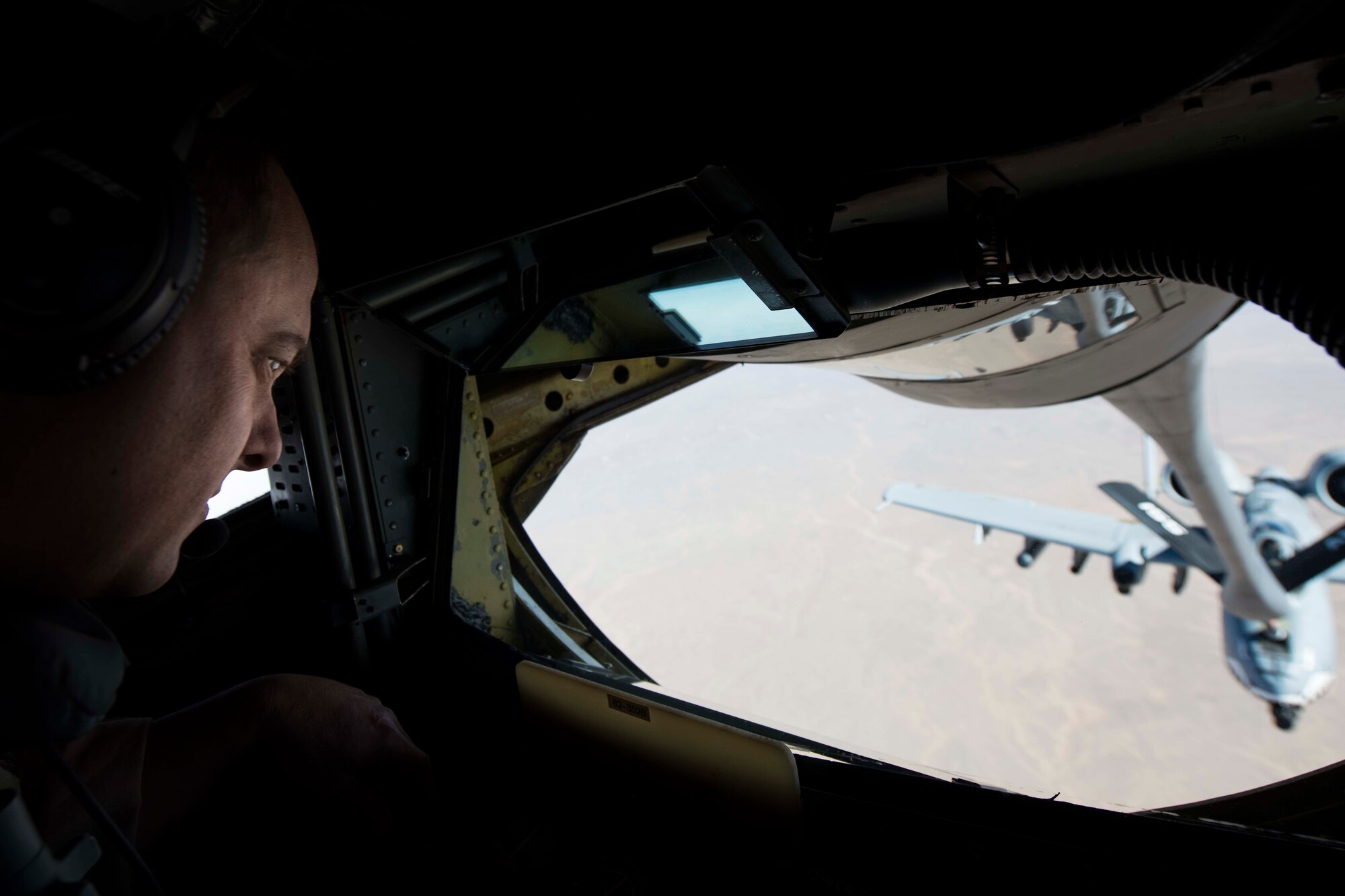 U.S. Air Force Master Sgt. Mat Ellison, 340th Expeditionary Air Refueling Squadron KC-135 Stratotanker boom operator, fuels an A-10 Thunderbolt II, assigned to the 75th Expeditionary Fighter Squadron, while flying over Kandahar Province, Afghanistan, Nov. 18, 2018.