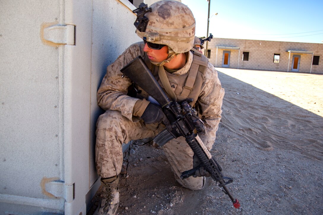 Cpl. Benjamin Lammers peers around a building during urban effects training on Camp Wilson, Marine Corps Air Ground Combat Center Twentynine Palms, California, Nov. 12, 2018. Marines with Transportation Services Company, Combat Logistics Battalion 4, Combat Logistics Regiment 3, 3rd Marine Logistics Group, maneuvered through a simulated combat town in tactical vehicles to improve efficiency in combat environments. ITX 1-19 is a large-scale Marine Air-Ground Task Force integration exercise in which CLB-4 Marines and Sailors train to respond quickly to any contingency by fully integrating with ground and air combat elements of the MAGTF. Stephens is a native of Springfield, Missouri. (U.S. Marine Corps photo by Cpl. Joshua Pinkney)