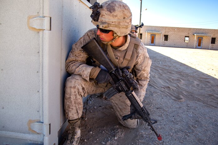 Cpl. Benjamin Lammers peers around a building during urban effects training on Camp Wilson, Marine Corps Air Ground Combat Center Twentynine Palms, California, Nov. 12, 2018. Marines with Transportation Services Company, Combat Logistics Battalion 4, Combat Logistics Regiment 3, 3rd Marine Logistics Group, maneuvered through a simulated combat town in tactical vehicles to improve efficiency in combat environments. ITX 1-19 is a large-scale Marine Air-Ground Task Force integration exercise in which CLB-4 Marines and Sailors train to respond quickly to any contingency by fully integrating with ground and air combat elements of the MAGTF. Stephens is a native of Springfield, Missouri. (U.S. Marine Corps photo by Cpl. Joshua Pinkney)