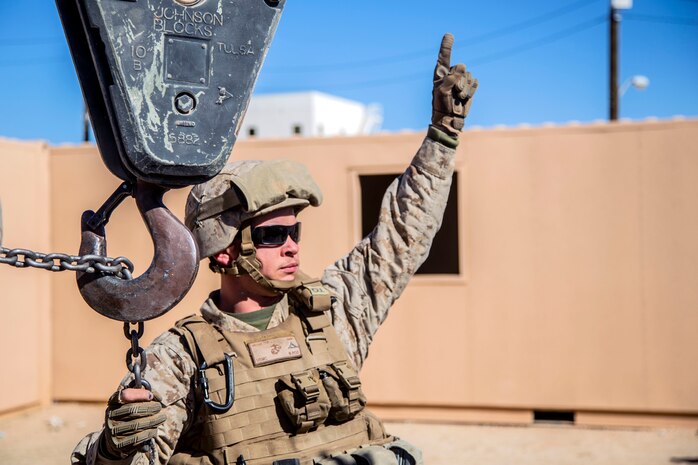 Lance Cpl. John VanMeter signals for a chain to be hoisted during urban effects training on Camp Wilson, Marine Corps Air Ground Combat Center Twentynine Palms, California, Nov. 12, 2018. Marines with Transportation Services Company, Combat Logistics Battalion 4, Combat Logistics Regiment 3, 3rd Marine Logistics Group, maneuvered through a simulated combat town in tactical vehicles to improve efficiency in combat environments. ITX 1-19 is a large-scale Marine Air-Ground Task Force integration exercise in which CLB-4 Marines and Sailors train to respond quickly to any contingency by fully integrating with ground and air combat elements of the MAGTF. VanMeter is a native of Fayetteville, Georgia. (U.S. Marine Corps photo by Cpl. Joshua Pinkney)