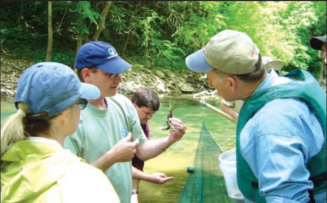 Dr. Richie Kessler, The Nature Conservancy, shows a bottlebrush crayfish to Lisa Morales, Corps headquarters, and John Paul Woodley, Jr., Assistant Secretary of the Army for Civil Works, during a visit to Green River.