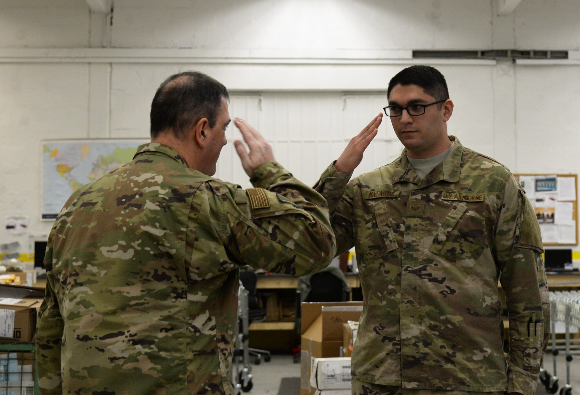 U.S. Air Force Staff Sgt. Dillion Matautia, 86th Logistics Readiness Squadron inbound cargo non-commissioned officer in charge, right, receives recognition from U.S. Air Force Brig. Gen. Mark August, 86th Airlift Wing commander, on Ramstein Air Base, Germany, Nov. 21, 2018.