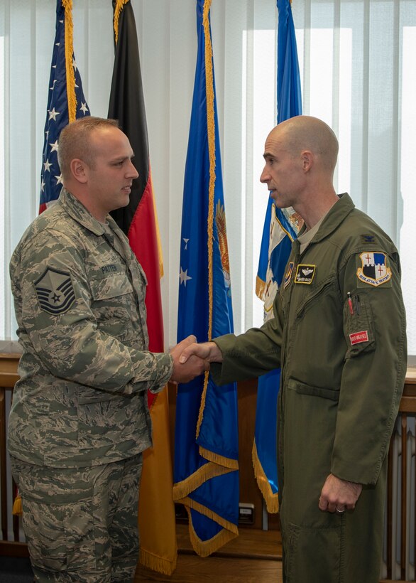 U.S. Air Force Master Sgt. Christopher Patten, 52nd Fighter Wing Innovation and Transformation Office problem identification training instructor, is coined by Col. Jason Bailey, 52nd Fighter Wing commander, at Spangdahlem Air Base, Germany, Nov. 16, 2018.