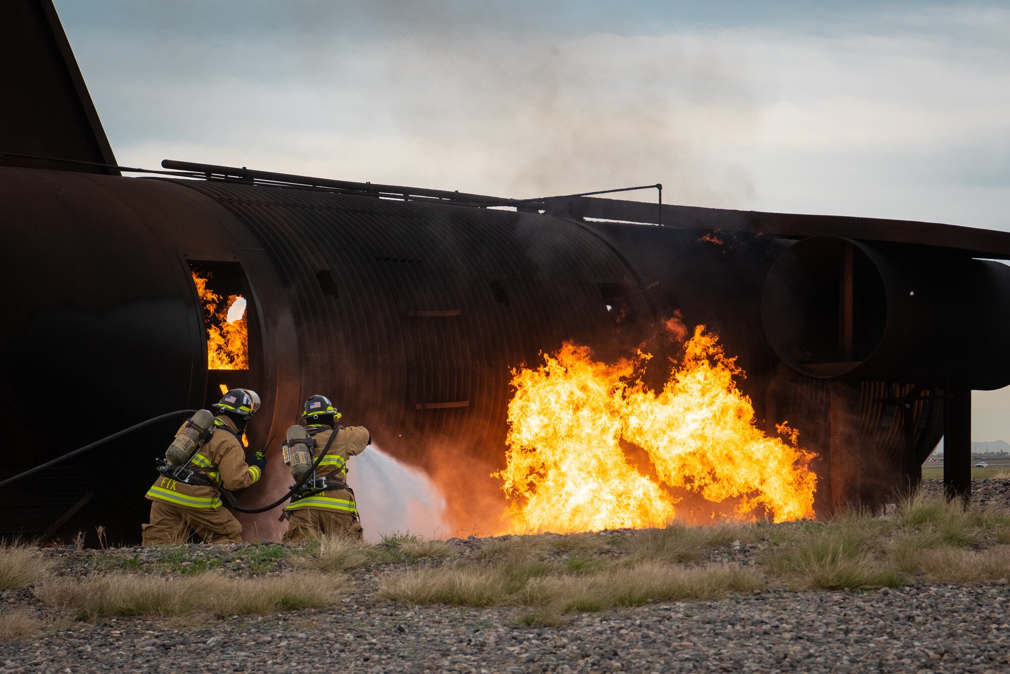 56th Civil Engineer Squadron firefighters spray water at a fuselage fire during a joint aircraft and structural live fire training, Nov. 14, 2018 at Luke Air Force Base, Ariz.