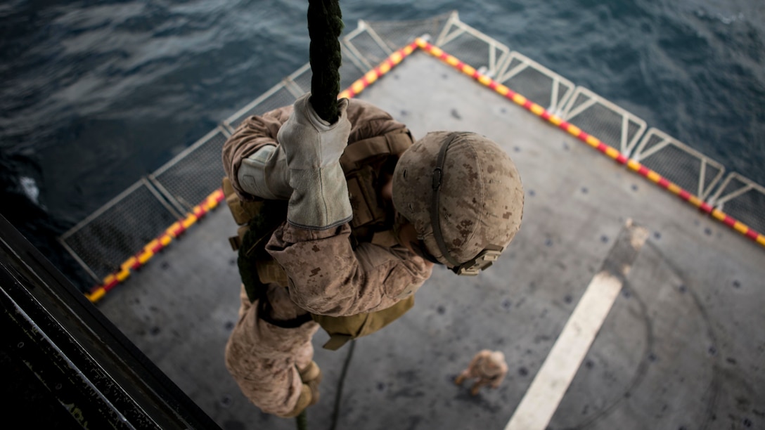 U.S. Marine Lance Cpl. Andrew Eisel, a rifleman with Lima Company, Battalion Landing Team 3/1, 13th Marine Expeditionary Unit, fast ropes out of an MV-22B Osprey from Marine Medium Tiltrotor Squadron 166 Reinforced, aboard the Wasp-class amphibious assault ship USS Essex, Nov. 20, 2018. The Essex is the flagship for the Essex ARG and, with the embarked 13th MEU, is deployed to the U.S. 5th Fleet area of operations in support of naval operations to ensure maritime stability and security in the Central Region, connecting the Mediterranean and the Pacific through the western Indian Ocean and three strategic choke points.