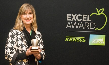 Kim Ware, a second grade teacher at Fort Sam Houston Elementary School, holds the KENS 5 Credit Human EXCEL Award she received during an assembly of teachers, students, parents and administrators at Fort Sam Houston Elementary School Nov. 13. Ware was the Fort Sam Houston Independent School District winner of the award. The EXCEL Award recognizes local public school teachers in each of the 19 San Antonio-area school districts who use innovative practices in the classroom and are making a difference in the lives of students in the classroom and beyond.