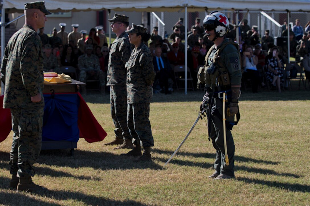 U.S. Marine Corps Col. David A. Suggs, commanding officer, Marine Corps Air Station Yuma, receives the ceremonial sword from a U.S. Navy Sailor assigned to Search and Rescue, at the Parade Deck on Marine Corps Air Station Yuma, Ariz., Nov. 8, 2018. The annual ceremony was held in honor of the 243rd Marine Corps birthday, showcasing historical uniforms to honor Marines of the past, present and future while signifying the passing of traditions from one generation to the next. (U.S. Marine Corps photo by Lance Cpl. Joel Soriano)