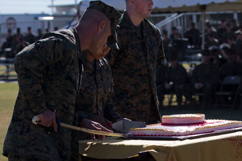 U.S. Marine Corps Col. David A. Suggs, commanding officer, Marine Corps Air Station Yuma, cuts a piece of birthday cake in the 243rd Marine Corps birthday uniform pageant at the Parade Deck on Marine Corps Air Station Yuma, Ariz., Nov. 8, 2018. The annual ceremony was held in honor of the 243rd Marine Corps birthday, showcasing historical uniforms to honor Marines of the past, present and future while signifying the passing of traditions from one generation to the next. (U.S. Marine Corps photo by Lance Cpl. Joel Soriano)