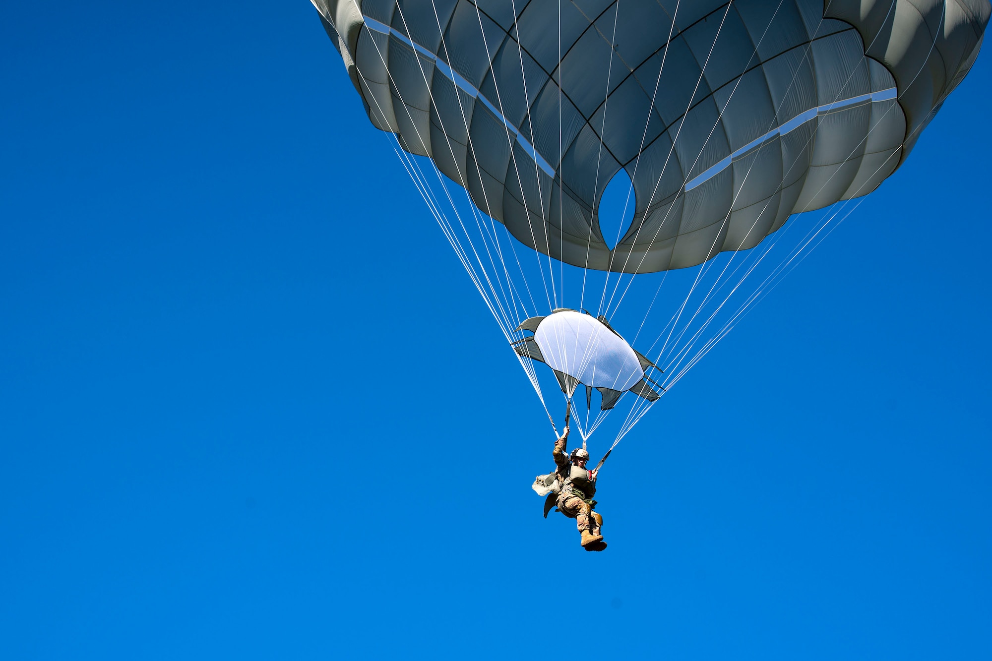 An Airman from the 93d Air Ground Operations Wing parachutes down during static-line jump training, Nov. 21, 2018, at Moody Air Force Base, Ga. The overall objective of the training was to increase jumpers’ skills, knowledge and proficiency in regards to airborne operations. During a static-line jump, the jumper is attached to the aircraft via the ‘static-line’, which automatically deploys the jumpers’ parachute after they’ve exited the aircraft. (U.S. Air Force photo by Airman 1st Class Erick Requadt)