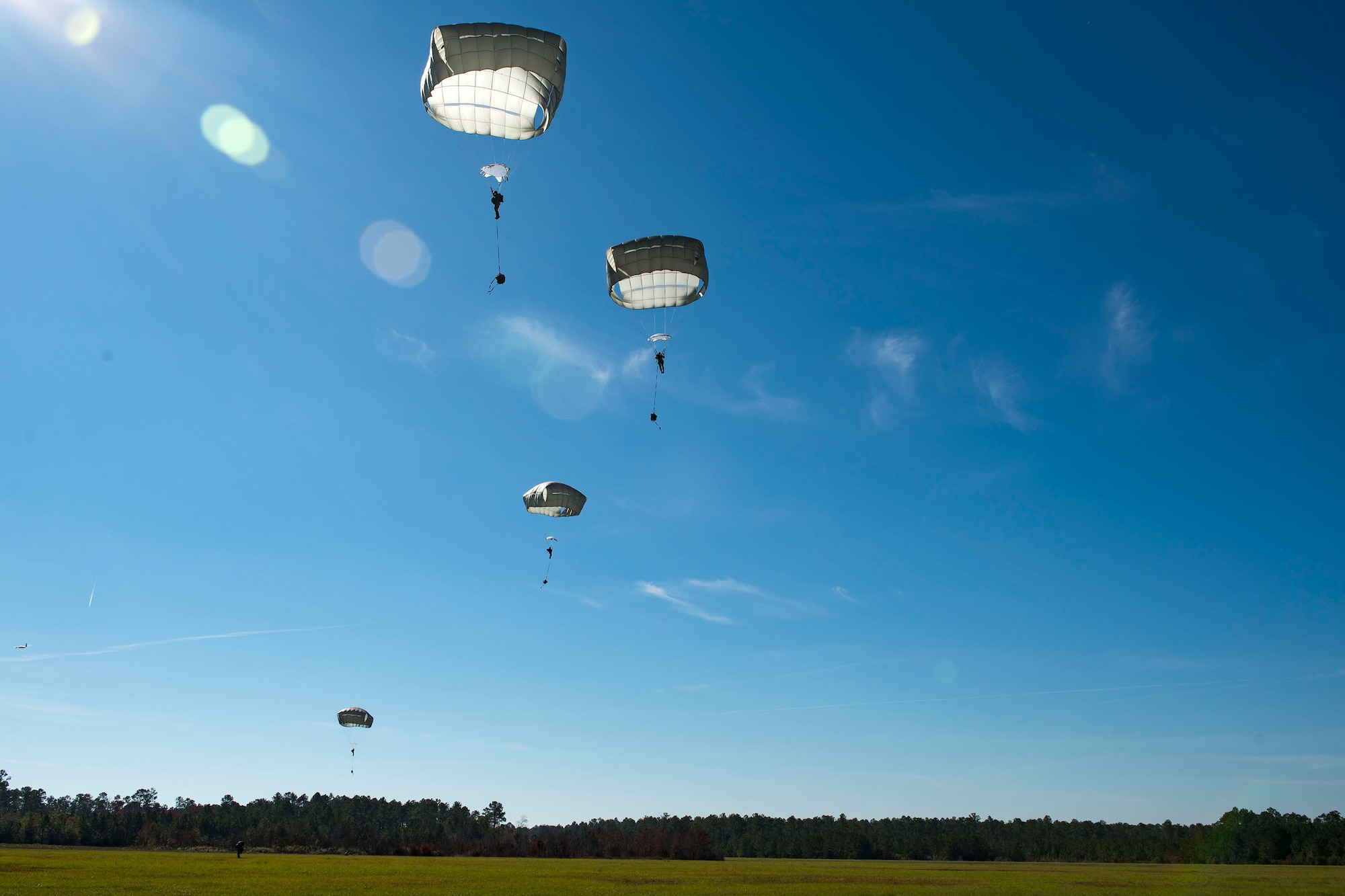 Airmen from the 93d Air Ground Operations Wing parachute down during static-line jump training, Nov. 21, 2018, at Moody Air Force Base, Ga. The overall objective of the training was to increase jumpers’ skills, knowledge and proficiency in regards to airborne operations. During a static-line jump, the jumper is attached to the aircraft via the ‘static-line’, which automatically deploys the jumpers’ parachute after they’ve exited the aircraft. (U.S. Air Force photo by Airman 1st Class Erick Requadt)