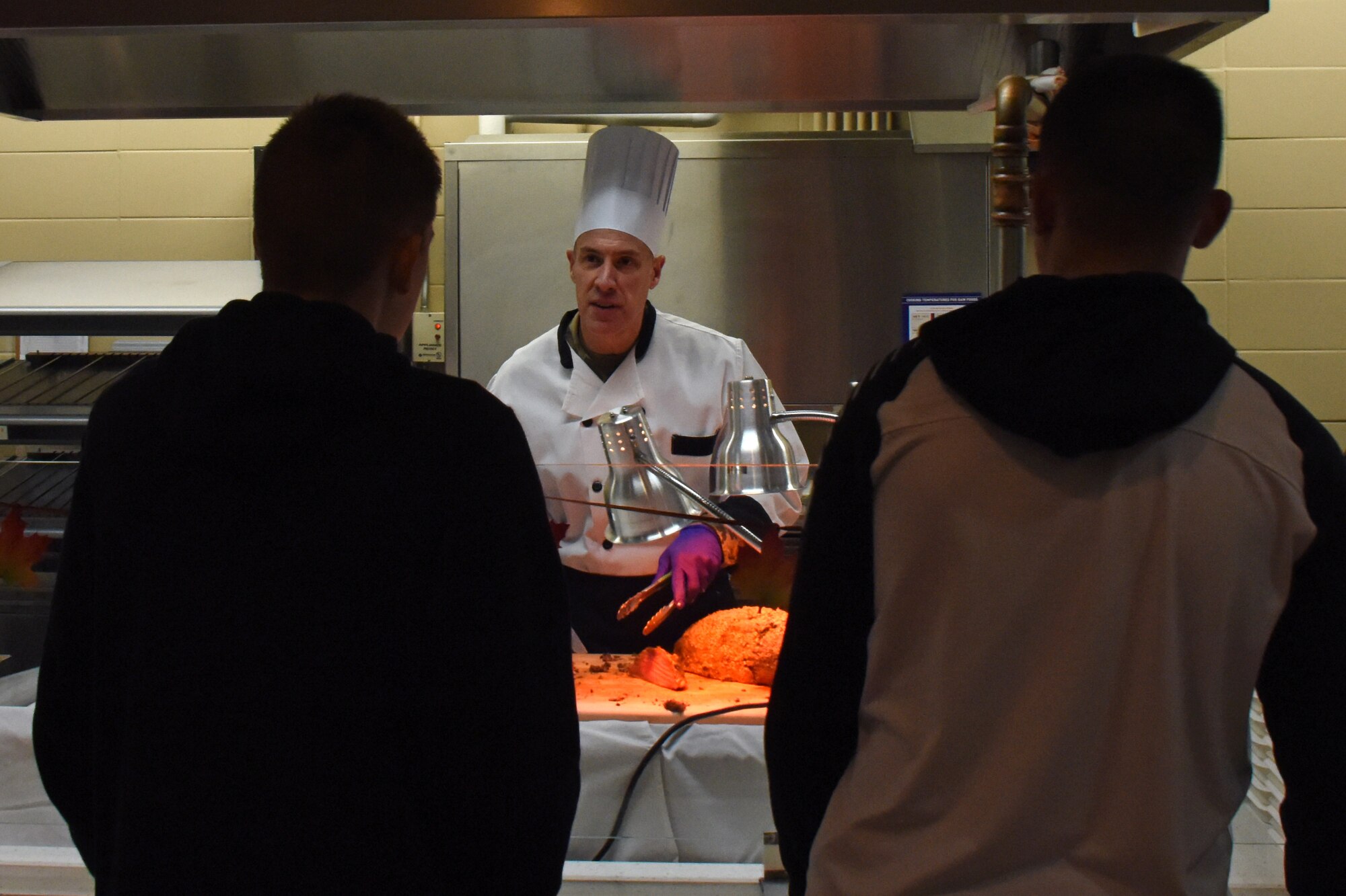 U.S. Air Force Col. Jason Beck, 17th Mission Support Group commander, offers food to attendees of the Thanksgiving Day lunch at the Western Winds Dining Facility on Goodfellow Air Force Base, Texas, Nov. 22, 2018. Leadership from the different groups and squadrons served food to the Goodfellow family. (U.S. Air Force photo by Airman 1st Class Zachary Chapman/Released)