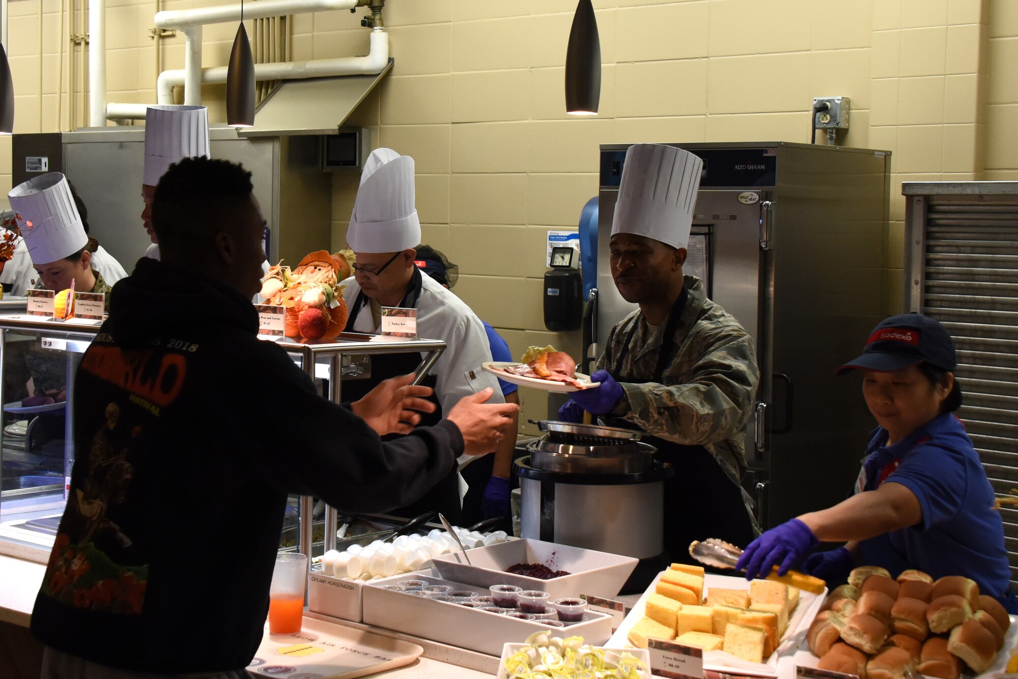 U.S. Air Force Maj. Michael Quinn, 17th Contracting Squadron commander, hands out food during the Thanksgiving Day lunch at the Western Winds Dining Facility on Goodfellow Air Force Base, Texas, Nov. 22, 2018. For those stationed at Goodfellow that were unable to go home to family and friends the lunch was a way to spread a bit of holiday spirits. (U.S. Air Force photo by Airman 1st Class Zachary Chapman/Released)