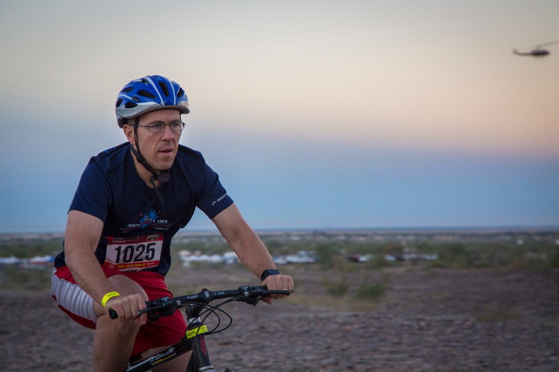 A competitor within the bike route participates in the first annual Telegraph Pass Challenge in Yuma, Ariz., Nov. 3, 2018. The challenge, coordinated by Marine Corps Community Services (MCCS), offered participants the opportunity to compete for first, second, or third place in either a 5 mile run, 5 mile bike route, or both. The course included a "Blue Mile" which is typically the most difficult portion of the racing event being a silent mile. The "Blue Mile" honors and remembers all fallen heroes of the Military, Police, and Fire Department. (U.S. Marine Corps photo by Sgt. Allison Lotz)