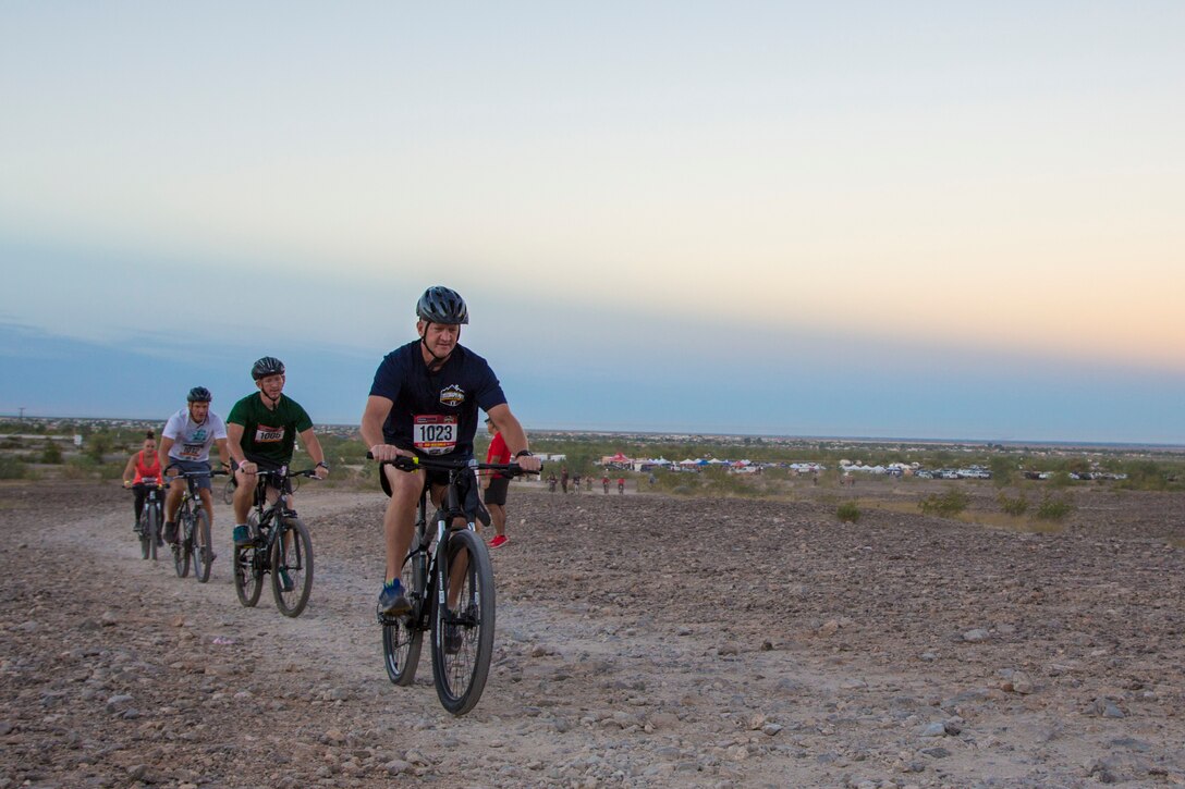 U.S. Marine Corps Sgt. Maj. David M. Leikwold, sergeant major of Marine Corps Air Station Yuma leads a line of bike competitors participating in the first annual Telegraph Pass Challenge in Yuma, Ariz., Nov. 3, 2018. The challenge, coordinated by Marine Corps Community Services (MCCS), offered participants the opportunity to compete for first, second, or third place in either a 5 mile run, 5 mile bike route, or both. The course included a "Blue Mile" which is typically the most difficult portion of the racing event being a silent mile. The "Blue Mile" honors and remembers all fallen heroes of the Military, Police, and Fire Department. (U.S. Marine Corps photo by Sgt. Allison Lotz)