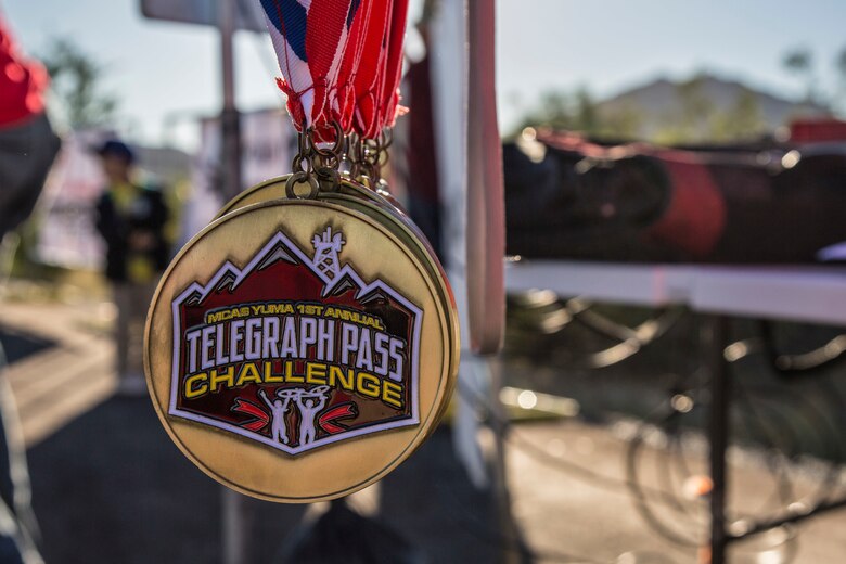 U.S. Marines, Sailors, and civilians recieve medals after participating in the first annual Telegraph Pass Challenge in Yuma, Ariz., Nov. 3, 2018. The challenge, coordinated by Marine Corps Community Services (MCCS), offered participants the opportunity to compete for first, second, or third place in either a 5 mile run, 5 mile bike route, or both. The course included a "Blue Mile" which is typically the most difficult portion of the racing event being a silent mile. The "Blue Mile" honors and remembers all fallen heroes of the Military, Police, and Fire Department. (U.S. Marine Corps photo by Sgt. Allison Lotz)