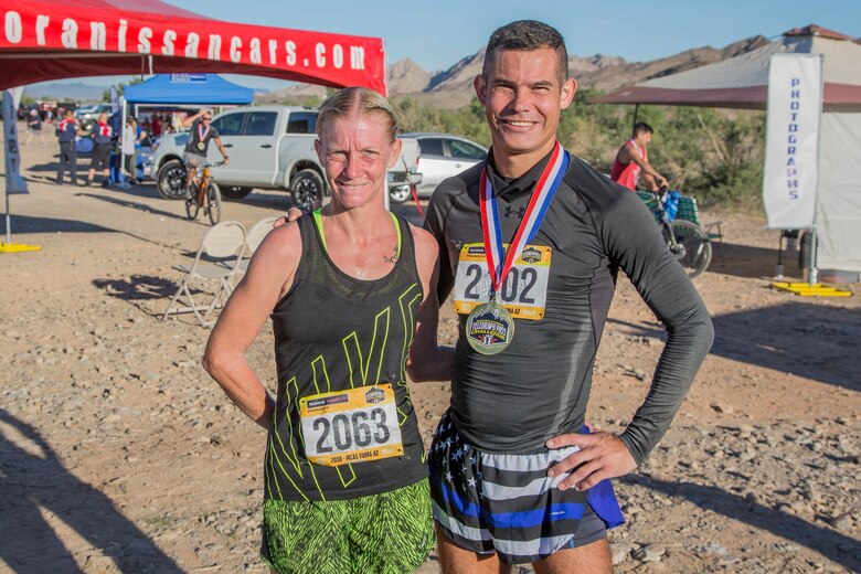 Amy Sautter, first place female run competitor, and Willard Smith Jr., first place male run competitor, pose for a photo after completing the first annual Telegraph Pass Challenge in Yuma, Ariz., Nov. 3, 2018. The challenge, coordinated by Marine Corps Community Services (MCCS), offered participants the opportunity to compete for first, second, or third place in either a 5 mile run, 5 mile bike route, or both. The course included a "Blue Mile" which is typically the most difficult portion of the racing event being a silent mile. The "Blue Mile" honors and remembers all fallen heroes of the Military, Police, and Fire Department. (U.S. Marine Corps photo by Sgt. Allison Lotz)