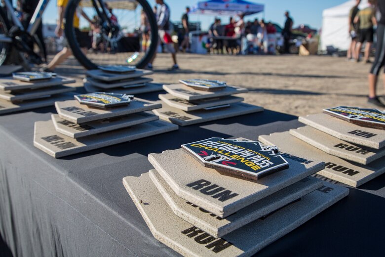First, second, and third place competitors recieve trophies after competing in the first annual Telegraph Pass Challenge in Yuma, Ariz., Nov. 3, 2018. The challenge, coordinated by Marine Corps Community Services (MCCS), offered participants the opportunity to compete for first, second, or third place in either a 5 mile run, 5 mile bike route, or both. The course included a "Blue Mile" which is typically the most difficult portion of the racing event being a silent mile. The "Blue Mile" honors and remembers all fallen heroes of the Military, Police, and Fire Department. (U.S. Marine Corps photo by Sgt. Allison Lotz)