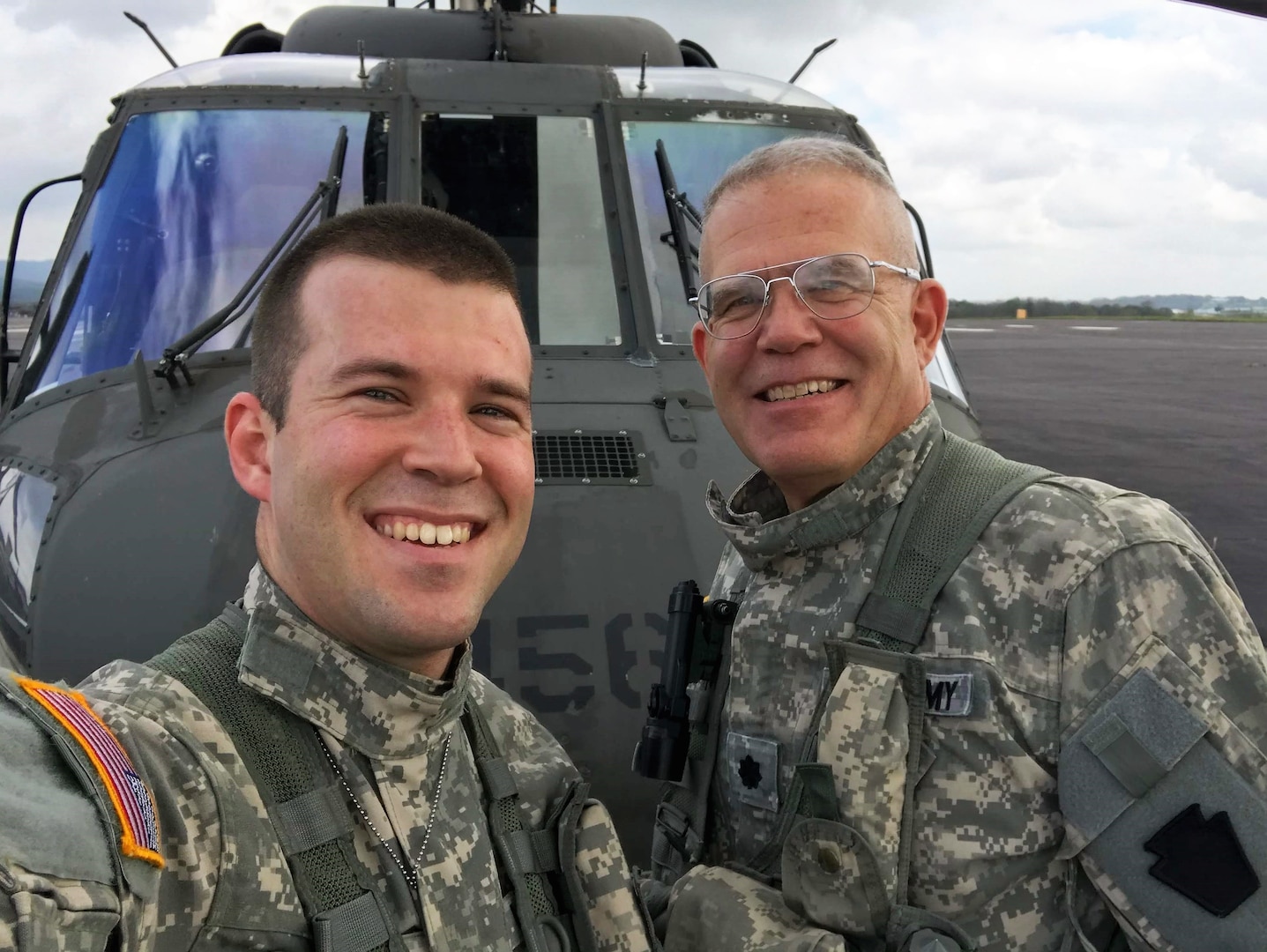 U.S. Army 1st Lt. Ian Lloyd, left, and Col. Howard Lloyd, both with the 28th Expeditionary Combat Aviation Brigade, pose in front of a UH-60 Black Hawk helicopter at Muir Army Airfield, October 9, 2018.