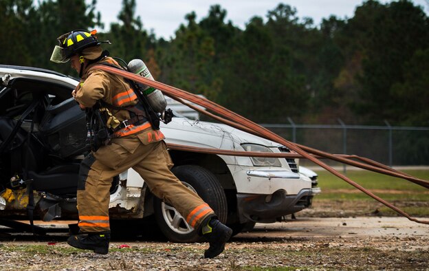 U.S. Air Force Airman 1st Class Dyllon Banks, 20th Civil Engineer Squadron firefighter, pulls a firehose to a controlled fire at Shaw Air Force Base, S.C., Nov. 20, 2018.