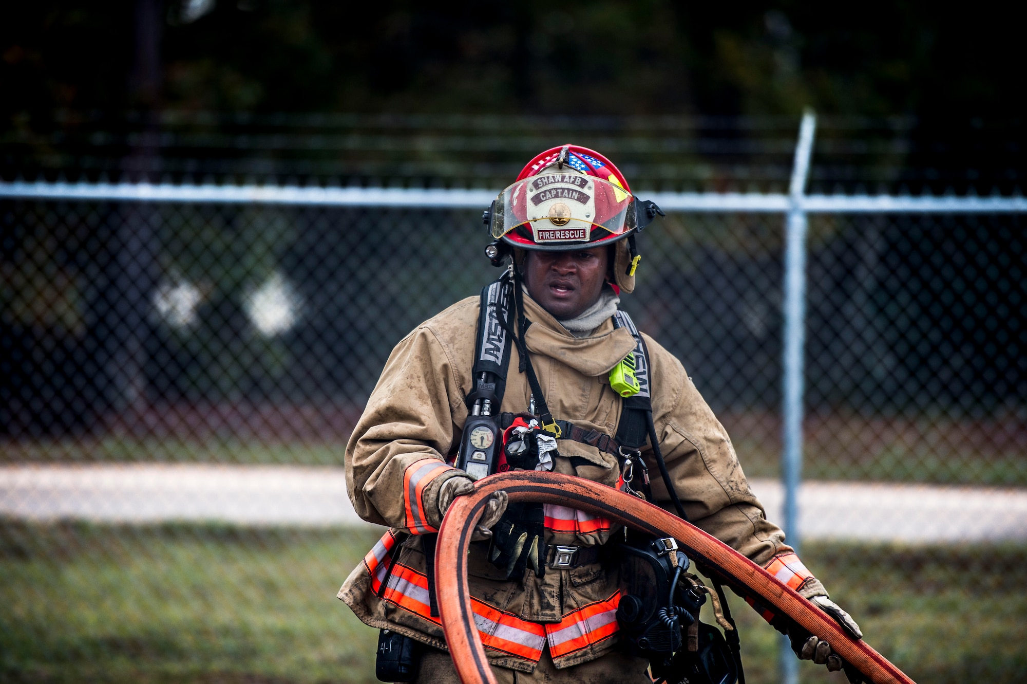 U.S. Air Force Tech. Sgt. Patrick Bentley, 20th Civil Engineer Squadron station captain, helps pull a hose from a building at Shaw Air Force Base, S.C., Nov. 20, 2018.