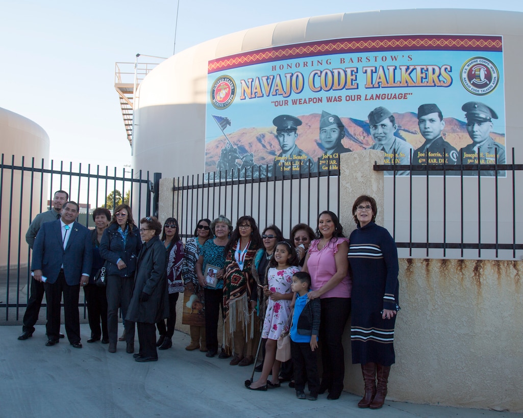 Mayor Julie Hackbarth-McIntyre and San Bernardino County Supervisor James Ramos pose with family members of the Barstow area Marines who served as Navajo Code Talkers, during an event dedicating the new Navajo Cold Talker Mural to them held in Barstow, Calif., Nov. 11. The families of the five United States Marines who served as Navajo Code Talkers during World War II, were able to speak to the crowd about their relatives' proud service to the Corps and to the United States of America. The ceremony included awards, certificates, and high praise from Mayor Julie Hackbarth-McIntyre, San Bernardino County Supervisor James Ramos, Assemblyman Jay Obernolte, as well as the commanding officer of Marine Corps Logistics Base Barstow. After their service during the war, the Marines came to the Barstow area, working for MCLB Barstow until their service ended. Some returned to work as civilians until they retired. The Marines honored on the mural, left to right: Jimmy L. Benally,  4th Marine Division, was awarded the Silver Medal; John Chee, 2nd Marine Division, was awarded the Gold Medal; Nelson Draper, Sr., 2nd Marine Division, was awarded the Silver Medal; Joe Morris, Sr., 6th Marine Division, was awarded the Silver Medal; Joseph H. Towne, 3rd Marine Division, was awarded the Silver Medal. Each entered into the Marine Corps as radiomen, unaware that their primary mission would be to use the secretive Navajo language as a code to help transmit top secret, mission-critical message to support the Marine Corps' war efforts. Their motto, "Our Weapon Was Our Language" is proudly displayed on the mural honoring these hometown heroes.