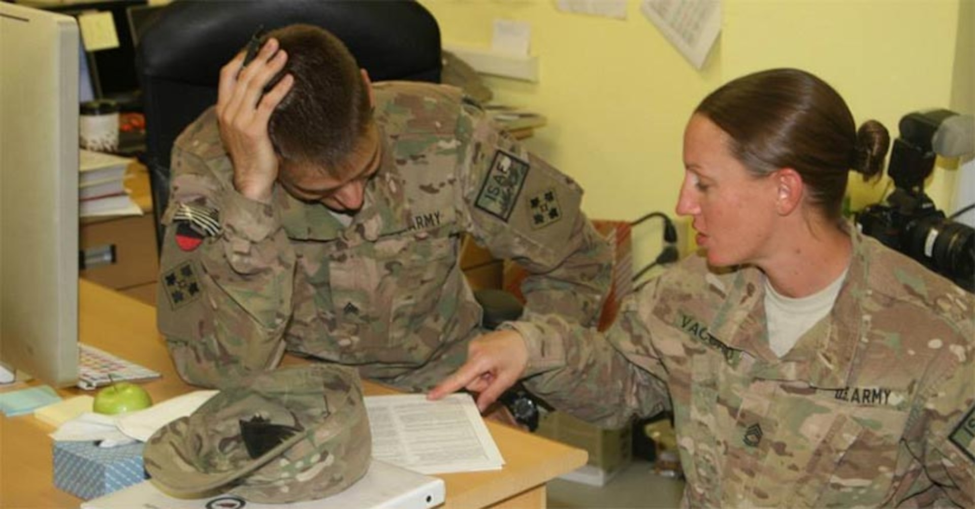 U.S. Army Sgt. 1st Class Danielle Vaccaro, a career counselor for headquarters and headquarters battalion, 4th Infantry Division, explains reenlistment options to U.S. Army Sgt. Eric Glassey, a public affairs operations noncommissioned officer, Kandahar, Afghanistan, Oct. 10, 2013.
