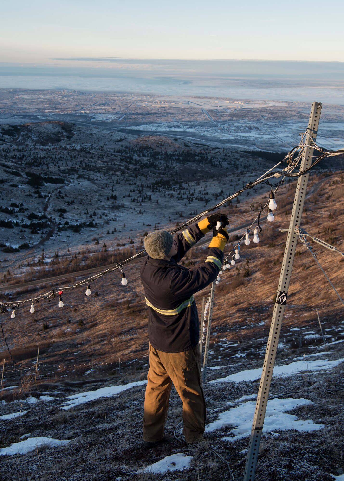U.S. Air Force Staff Sgt. Steven Andersen, 773d Civil Engineer Squadron electrical shop exterior electric noncommissioned officer in charge, examines wiring on the brightly lit star placed on the side of Mount Gordon Lyon at Joint Base Elmendorf-Richardson, Alaska, Nov. 23, 2018. The star spans more than 300 feet and is located in an area just below the old U.S. Army Air Defense Command Nike Hercules missile battery – one of three which defended the Anchorage bowl during the Cold War. Since 2010, Airmen from the 773d CES electrical shop have assumed caretaking responsibility for the stars location.