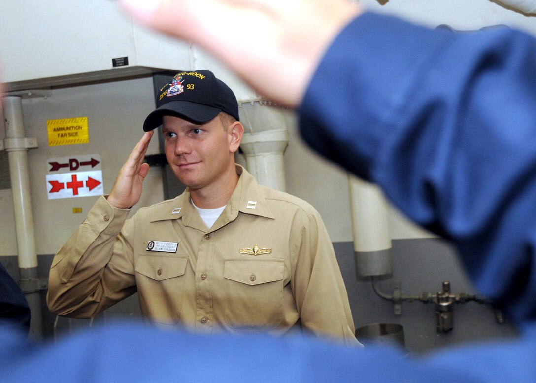 Navy Lt. Billy Hurley III salutes other sailors in uniform