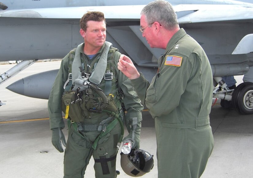 Golfer Shaun Micheel wears a flight suit while talking to a flight instructor.