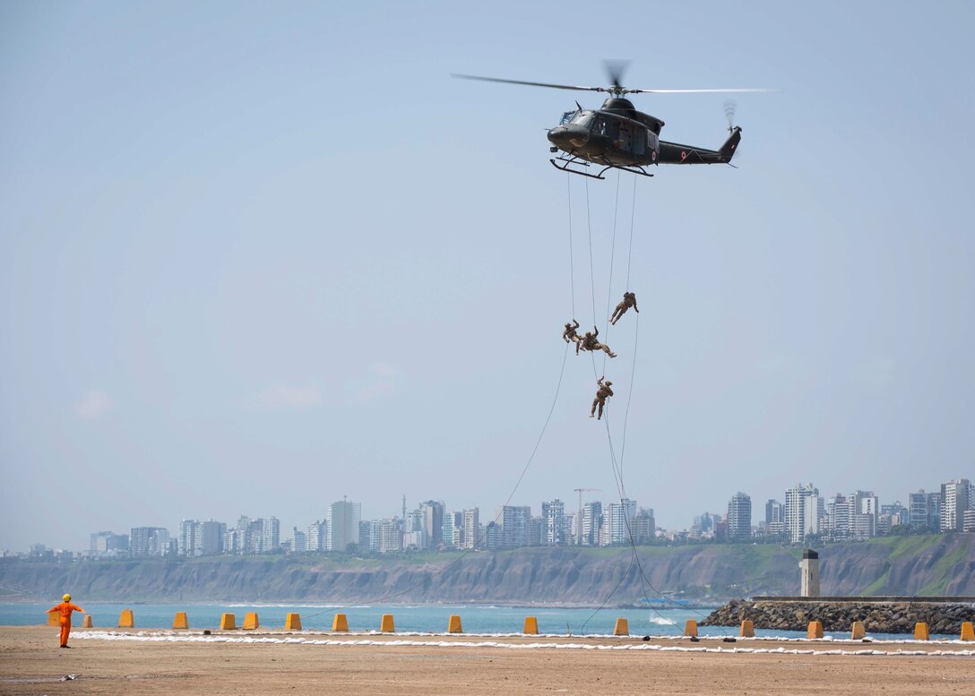 Four Peruvian airmen rappel from a Peruvian Air Force helicopter during a humanitarian assistance and disaster relief demonstration between U.S. Marines with Special Purpose Marine Air-Ground Task Force - Peru and Peruvian naval forces Nov. 24, 2018.