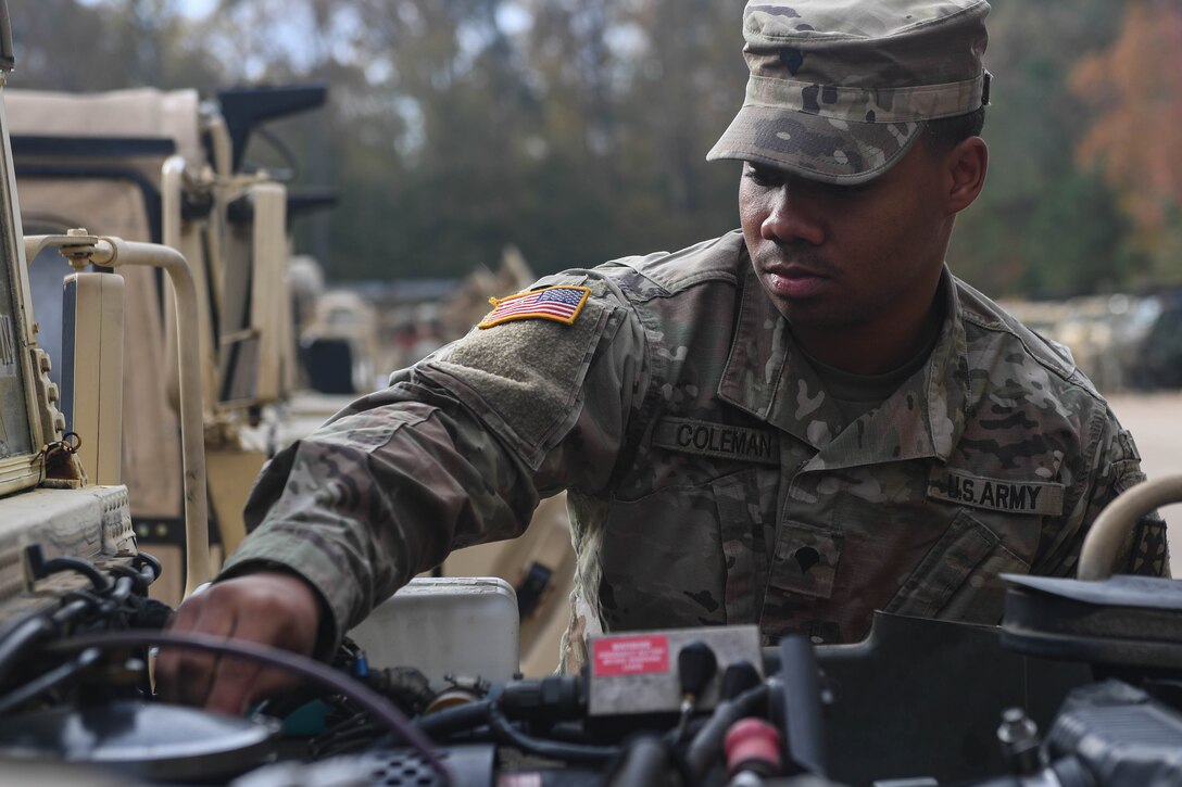 U.S. Army Spc. Takory Coleman, 149th Seaport Operations Company, 10th Transportation Battalion, 7th Trans. Brigade (Expeditionary) transportation management coordinator, checks the oil of a HUMVEE at Joint Base Langley-Eustis, Virginia, Nov. 19, 2018. The vehicle mechanics of the 149th SOC conduct preventative maintenance checks every week to limit and identify any issues the vehicles may have. (U.S. Air Force photo by Senior Airman Derek Seifert)