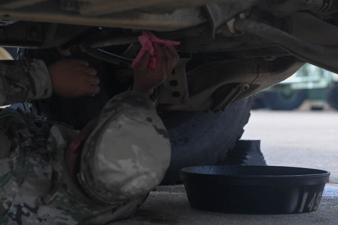 U.S. Army Spc. Takory Coleman, 149th Seaport Operations Company, 10th Transportation Battalion, 7th Trans. Brigade (Expeditionary) transportation management coordinator, checks fuel lines on a HUMVEE at Joint Base Langley-Eustis, Virginia, Nov. 19, 2018. During preventative maintenance checks, Coleman checked the oil, fuel lines, lights and the engine. (U.S. Air Force photo by Senior Airman Derek Seifert)