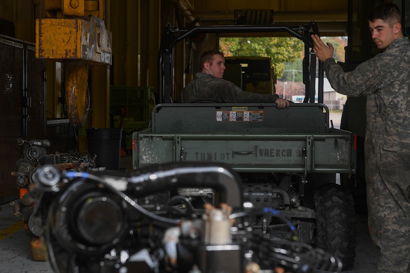 U.S. Army Spc. Lathan Griener, 149th Seaport Operations Company, 10th Transportation Battalion, 7th Trans. Brigade (Expeditionary) welder, guides Spc. Waylon Brown, 149th SOC, 10th Trans. Bn., 7th Trans. Bde. (Ex) mechanic, pulling an engine under a crane at Joint Base Langley-Eustis, Virginia, Nov. 19, 2018. The 149th SOC maintains, manages and repairs the vehicles assigned to the battalion, which include all wheeled vehicles, as well as generators, air conditioning units, night vision goggles and watercraft. (U.S. Air Force photo by Senior Airman Derek Seifert)