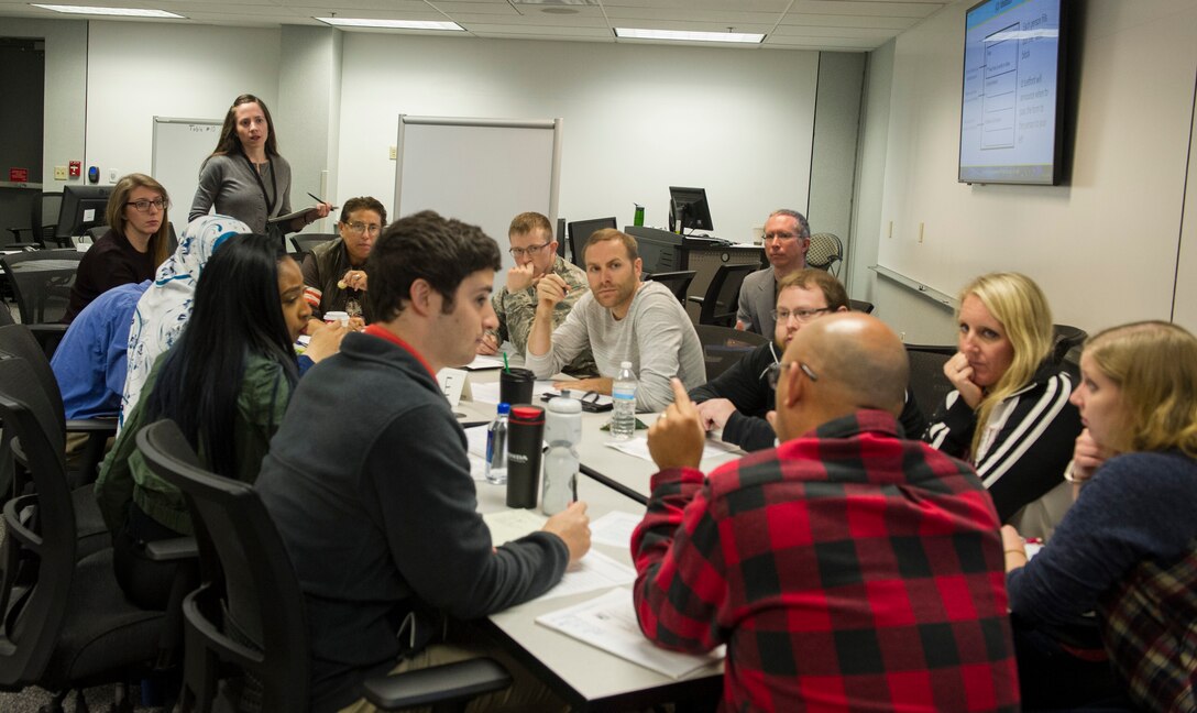 National Air and Space Intelligence Center members collaborate on their task during the Hack4NASIC event at NASIC Oct. 11, 2018. The Hack4NASIC brought members from across the Center to collaborate on problems to improve NASIC’s systems. (U.S. Air Force photo by Senior Airman Michael Hunsaker)