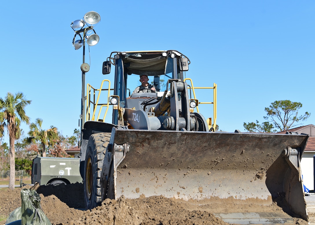 Senior Airman Justin Courtney, a member of Task Force Phoenix and the 375th Civil Engineer Squadron pavements and heavy equipment operator, transfers soil while at Tyndall Air Force Base, Fla., Nov. 27, 2018. Task Force Phoenix is responsible for large-scale clean up and reconstruction after Hurricane Michael ravaged Tyndall Air Force Base and the panhandle of Florida. (U.S. Air Force photo by Senior Airman Isaiah J. Soliz)