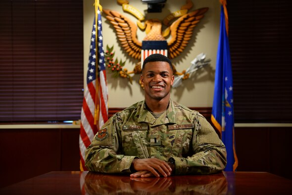 First Lieutenant Mickel McGann, 47th Flying Training Wing Public Affairs deputy chief, poses as a test subject for his Airmen as they set up for a video interview, Nov. 6, 2018, at Laughlin Air Force Base, Texas. One of his primary duties is media operations, which includes overseeing interviews with outside media and working with any type of video communication. (U.S. Air Force photo by Senior Airman Benjamin Valmoja)