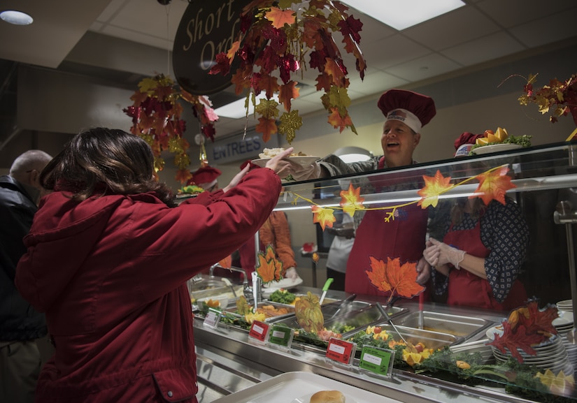 U.S. Air Force Col. Neil Richardson, Joint Base McGuire-Dix-Lakehurst and 87th Air Base Wing commander, hands a plate of food to a community member during Thanksgiving dinner on Joint Base MDL, New Jersey, Nov. 22, 2018. Richardson and his family served food to military members at the event before returning to their house for dinner. (U.S. Air Force photo by Airman 1st Class Ariel Owings)